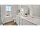 Elegant bathroom with double vanity, modern fixtures, and a window offering natural light and neighborhood view at 73 Windswept Way, Fuquay Varina, NC 27526