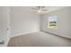 Bright bedroom with neutral carpet, ceiling fan, and a window showcasing a lovely neighborhood view at 73 Windswept Way, Fuquay Varina, NC 27526