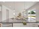 Kitchen island with sink and stone countertop overlooks living area with fireplace at 73 Windswept Way, Fuquay Varina, NC 27526