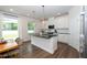 Bright kitchen with an island, black countertops, white cabinets, and stainless steel appliances at 73 Windswept Way, Fuquay Varina, NC 27526