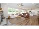 Open-concept living room featuring hardwood floors, many windows, and a view to the modern kitchen at 73 Windswept Way, Fuquay Varina, NC 27526