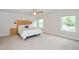 Bright main bedroom features a chevron headboard, carpet flooring, and a ceiling fan at 73 Windswept Way, Fuquay Varina, NC 27526