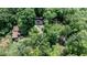 Aerial view of wooded property featuring house, detached garage, and in-ground trampoline at 82 Deercorn Path, Moncure, NC 27559