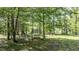 Secluded backyard space featuring a play area, trampoline, and wooded surroundings at 82 Deercorn Path, Moncure, NC 27559