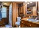A rustic bathroom featuring wood paneled walls, a single sink vanity, and a bathtub-shower combo at 82 Deercorn Path, Moncure, NC 27559