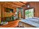 A cozy main bedroom featuring wood paneling, stone fireplace, and a comfortable bed, perfect for relaxation at 82 Deercorn Path, Moncure, NC 27559