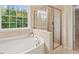 Spa-like bathroom featuring a soaking tub and separate glass-enclosed shower at 901 Lemongrass Ln, Wake Forest, NC 27587