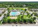 Aerial view of community pool with lounge chairs, a playground and volleyball court surrounded by trees at 901 Lemongrass Ln, Wake Forest, NC 27587