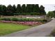 A beautifully landscaped entrance to a community with lush flowers and shrubbery at 901 Lemongrass Ln, Wake Forest, NC 27587