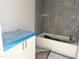 Bathroom featuring a new tub with modern gray tile surround and white vanity at 901 Linwood Ave, Durham, NC 27701