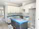 A bright kitchen featuring white cabinets and an island covered in blue protective plastic at 901 Linwood Ave, Durham, NC 27701