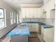A bright kitchen featuring white cabinets and an island covered in protective plastic at 901 Linwood Ave, Durham, NC 27701