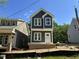 A modern two-story home displaying gray siding, white trim, and a minimalist design in bright sunlight at 903 Linwood Ave, Durham, NC 27701