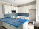 Bright, unfinished kitchen with sleek white cabinets and a modern, light-blue backsplash at 903 Linwood Ave, Durham, NC 27701