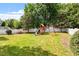 Green backyard featuring a playset and a white picket fence at 9117 Meadow Mist Ct, Raleigh, NC 27617