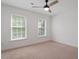 Cozy bedroom featuring neutral carpet, a ceiling fan, and bright windows at 9117 Meadow Mist Ct, Raleigh, NC 27617