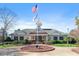 Community clubhouse featuring landscaped grounds, patriotic flags, and classic architectural details at 9117 Meadow Mist Ct, Raleigh, NC 27617