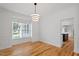 Elegant dining room features hardwood floors, white walls with wainscoting, and modern light fixture at 9117 Meadow Mist Ct, Raleigh, NC 27617