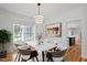 Elegant dining room with modern lighting fixture, wainscoting, and beautiful hardwood floors at 9117 Meadow Mist Ct, Raleigh, NC 27617