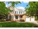 Charming brick and siding two-story home with lush green lawn, mature trees, and a welcoming front porch at 9117 Meadow Mist Ct, Raleigh, NC 27617