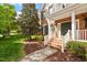 Inviting front porch with brick steps, white railings, and a well-manicured landscape leading to the entrance at 9117 Meadow Mist Ct, Raleigh, NC 27617