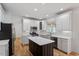 Modern kitchen featuring an island, stainless steel appliances, white cabinets, and hardwood floors at 9117 Meadow Mist Ct, Raleigh, NC 27617