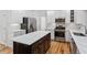 Open-concept kitchen featuring white cabinets, stainless steel appliances, and a center island with countertop at 9117 Meadow Mist Ct, Raleigh, NC 27617
