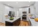 Kitchen featuring white cabinetry, stainless steel appliances, island with black cabinets, and hardwood floors at 9117 Meadow Mist Ct, Raleigh, NC 27617
