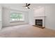 Comfortable living room featuring a brick fireplace, large window, and neutral carpet, creating a cozy ambiance at 9117 Meadow Mist Ct, Raleigh, NC 27617
