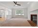 Comfortable living room featuring a brick fireplace, large window, and neutral carpet, creating a cozy ambiance at 9117 Meadow Mist Ct, Raleigh, NC 27617