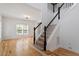 Carpeted staircase with white and black railing leading to the upper level and hardwood floors at 9117 Meadow Mist Ct, Raleigh, NC 27617