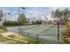 Community tennis court surrounded by a green fence and mature trees at 9117 Meadow Mist Ct, Raleigh, NC 27617