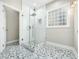Beautiful glass enclosed shower with white tiled walls and gray tile floors at 915 Edgewater Cir, Chapel Hill, NC 27516