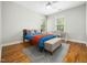 Cozy bedroom with hardwood floors, a bed with colorful linens, and a bright window desk space at 915 Edgewater Cir, Chapel Hill, NC 27516
