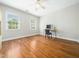 Sunlit bedroom featuring hardwood floors, neutral walls, and bright windows with a modern computer desk at 915 Edgewater Cir, Chapel Hill, NC 27516