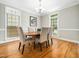 Dining room featuring a wooden table and four chairs, bathed in natural light from large windows at 915 Edgewater Cir, Chapel Hill, NC 27516