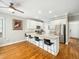 Bright eat-in kitchen features white cabinets, stainless appliances, and a large center island with bar stool seating at 915 Edgewater Cir, Chapel Hill, NC 27516