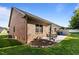 Brick home's outdoor patio with dining furniture, well-maintained lawn, and serene backyard views at 928 Arrowhead Ln, Mebane, NC 27302