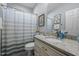 Well-lit bathroom featuring a granite countertop, vanity, and striped shower curtain at 928 Arrowhead Ln, Mebane, NC 27302
