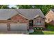 Charming brick home featuring an attached garage and beautifully landscaped front yard at 928 Arrowhead Ln, Mebane, NC 27302