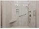 Modern shower with a glass door, built-in shelves, seat, and handrails for safety at 928 Arrowhead Ln, Mebane, NC 27302