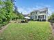 Expansive backyard with patio, fire pit, seating, and lush greenery at 948 Uprock Dr, Cary, NC 27519