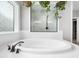 Bathroom features an oversized soaking tub with a white tile surround and plants at 948 Uprock Dr, Cary, NC 27519