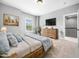Bedroom features a wooden bed frame, matching dresser with TV, and large window at 948 Uprock Dr, Cary, NC 27519