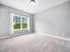 Bright bedroom features a large window with natural sunlight and neutral colored carpet at 948 Uprock Dr, Cary, NC 27519