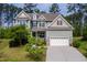 Charming two-story home with a manicured lawn, two-car garage and inviting front porch nestled among mature trees at 948 Uprock Dr, Cary, NC 27519