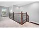 Upstairs hallway features decorative wooden railing and neutral carpet at 948 Uprock Dr, Cary, NC 27519