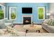 Cozy living room with a fireplace and large windows overlooking the backyard at 948 Uprock Dr, Cary, NC 27519