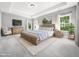 Staged main bedroom with wood furniture set, white carpet, and three large windows at 948 Uprock Dr, Cary, NC 27519