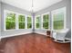 Sunroom filled with natural light, showcasing views of the surrounding greenery and a wicker rocking chair at 948 Uprock Dr, Cary, NC 27519